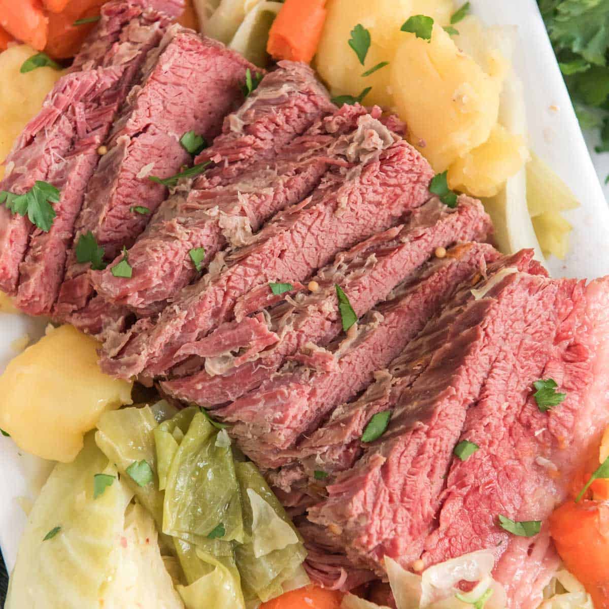 corned beef and cabbage on white platter with carrots and potatoes