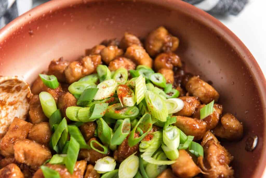 szechuan chicken and green onion in skillet