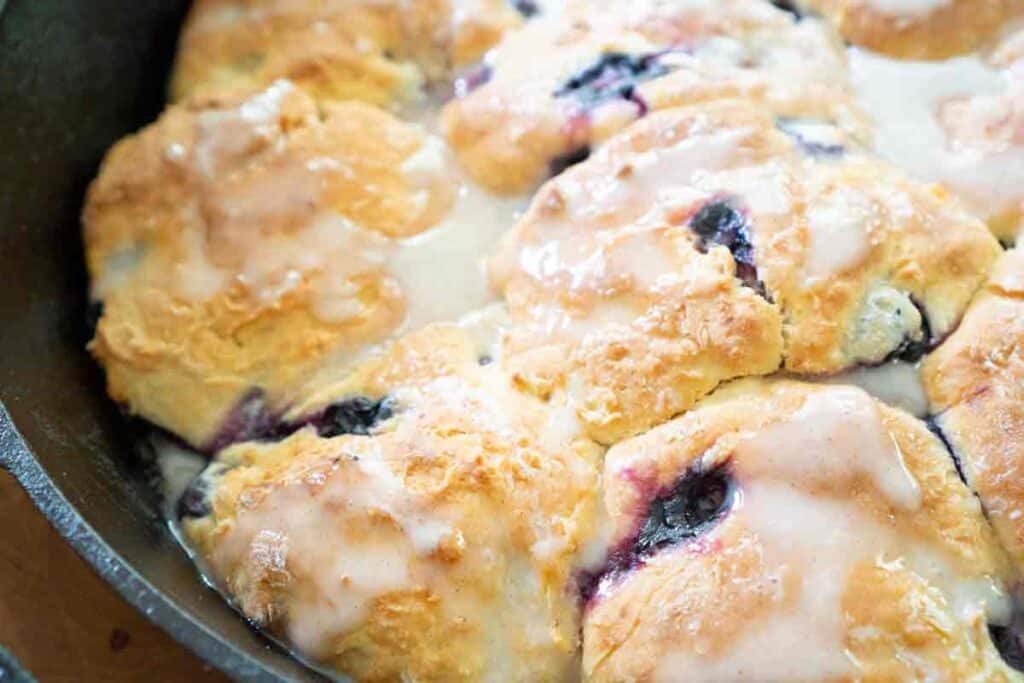 close up photo of blueberry buttermilk biscuits in cast iron skillet