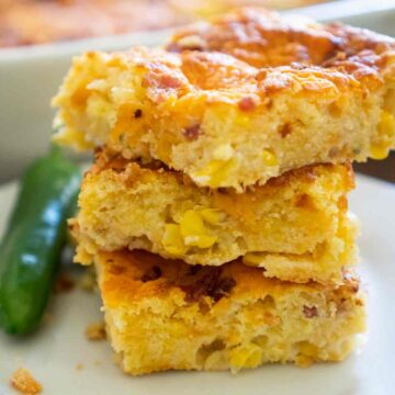 three pieces of stacked jalapeno cheddar cornbread on white plate