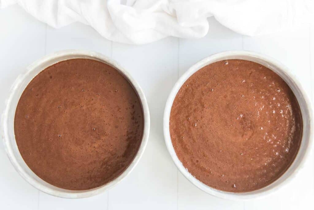 two cake pans from overhead filled with chocolate cake batter