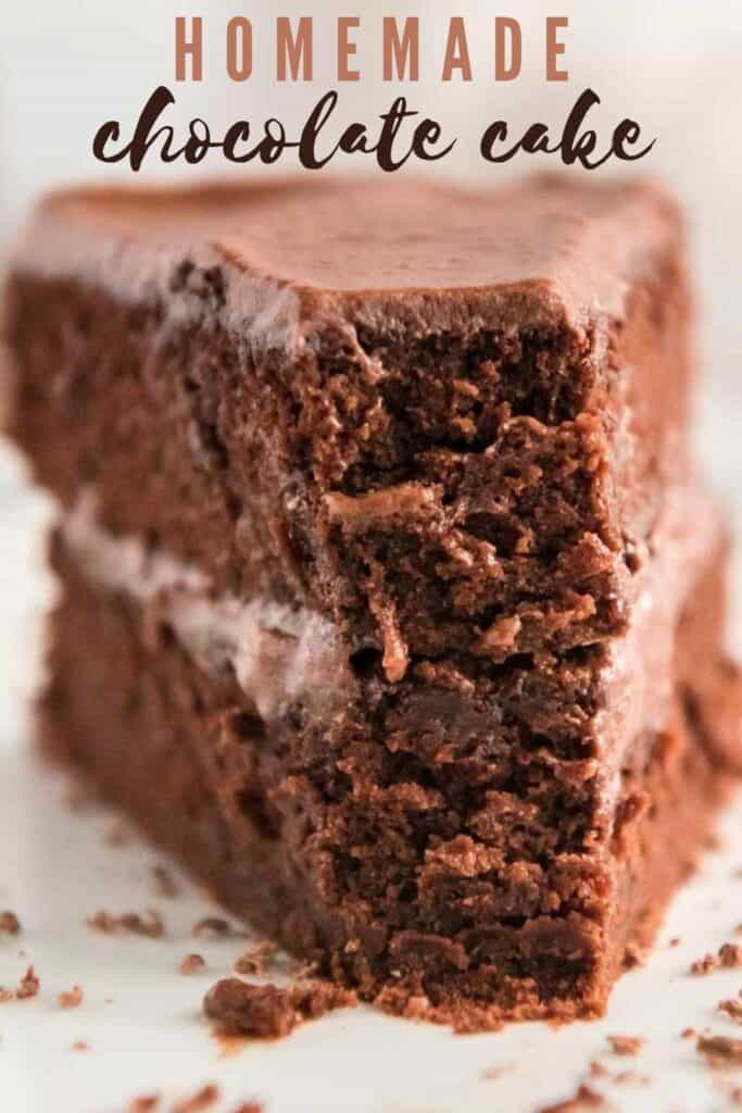 slice of chocolate cake on white plate with bite missing and text reading homemade chocolate cake