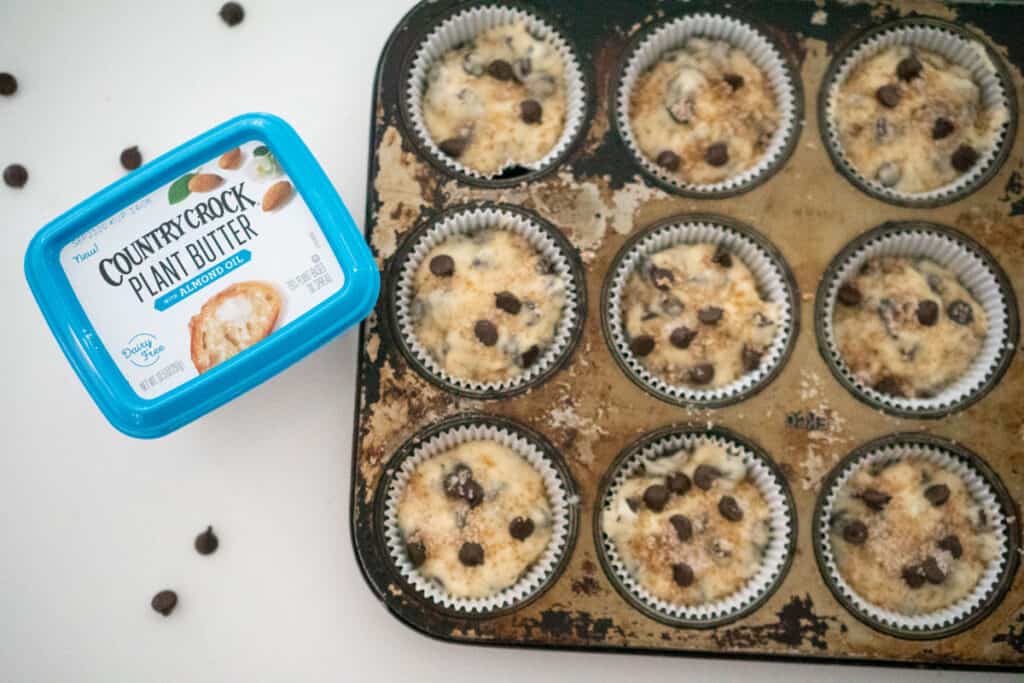 chocolate chip muffins in baking pan next to tub of country crock plant butter