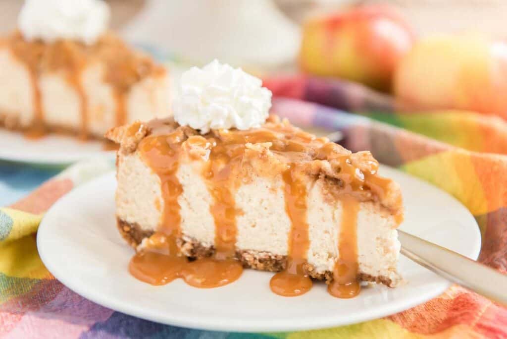 slice of apple crisp cheesecake on white plate