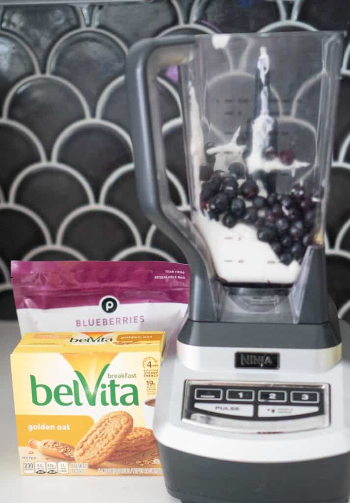 blender with yogurt and blueberries with box of breakfast biscuits nearby