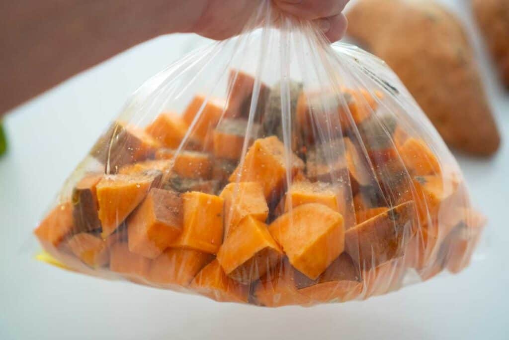 hand holding bag of cubed sweet potatoes
