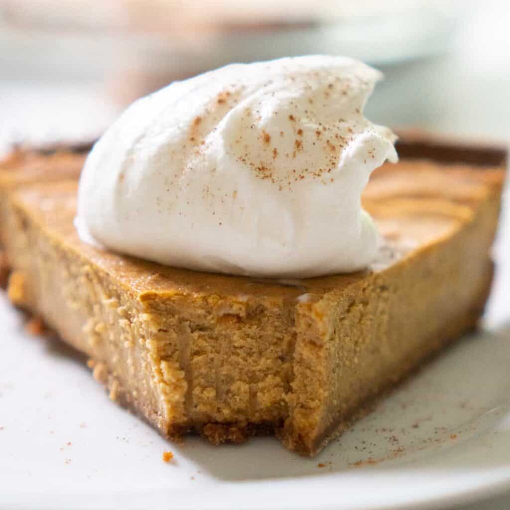 close up of pumpkin cheesecake with whipped cream 