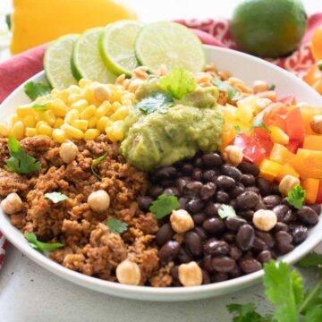 close up of vegetarian burrito bowl topped with guacamole