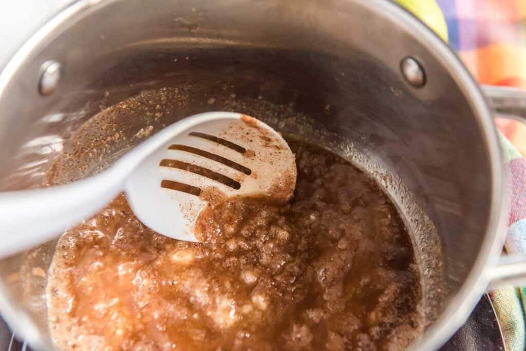spoon with apple caramel filling in pot