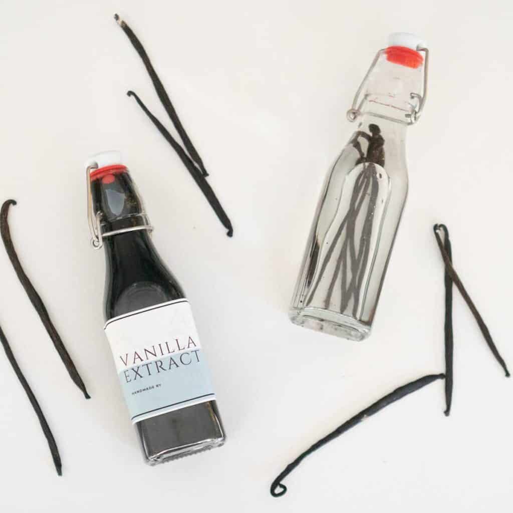 two bottles of homemade vanilla extract with vanilla bean pods