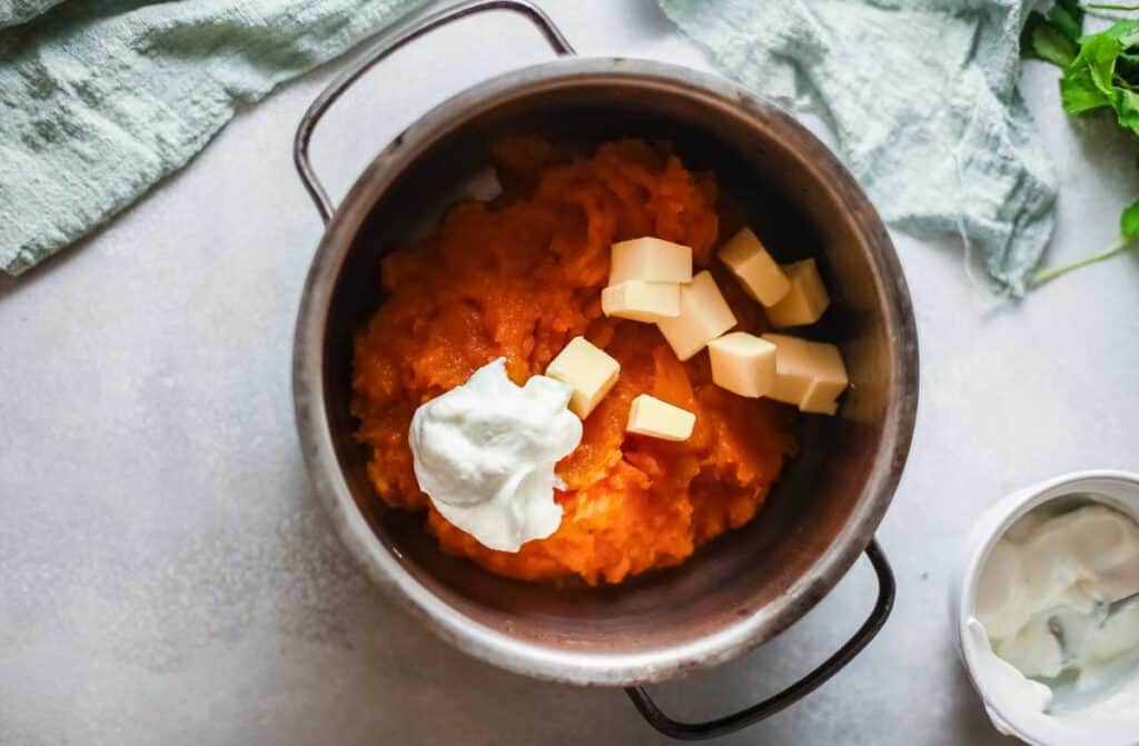 mashed sweet potatoes butter and sour cream in pot