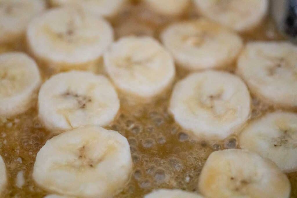 banana slices in simmering syrup