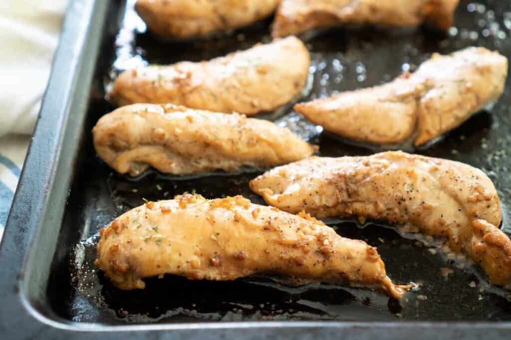 marinated chicken tenders on baking sheet