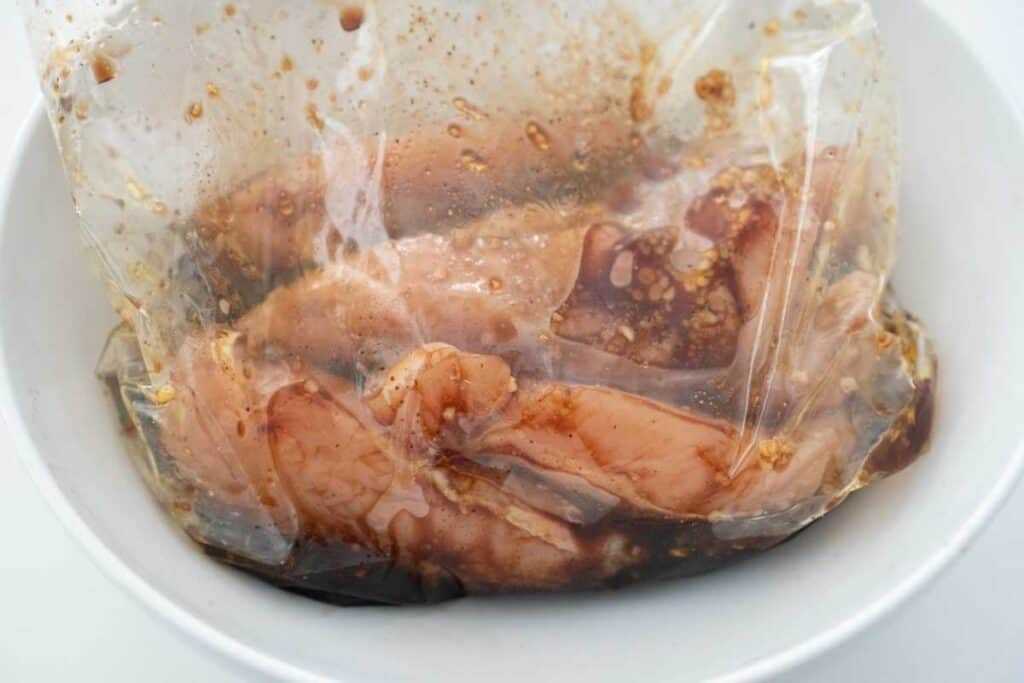 chicken tenderloins marinating in plastic bag