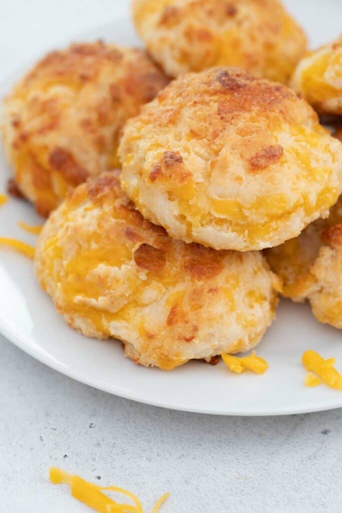 pile of cheddar garlic biscuits on white plate