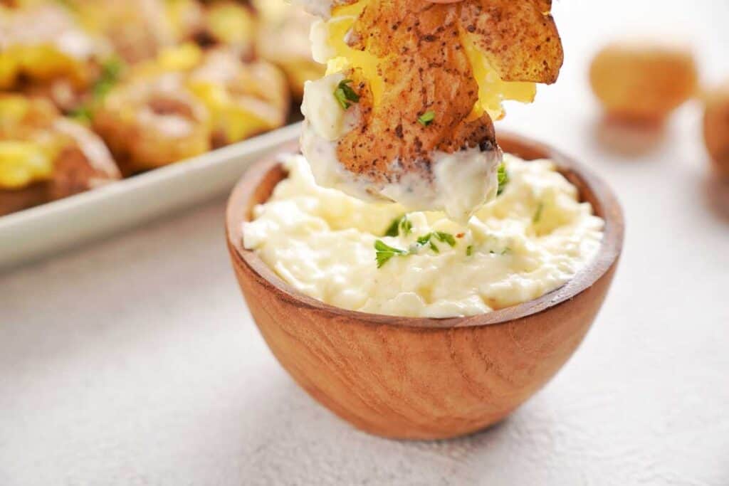 dipping a smashed potato in cheese dip