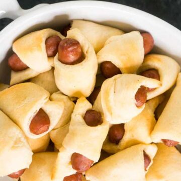 close up of pigs in a blanket in white bowl