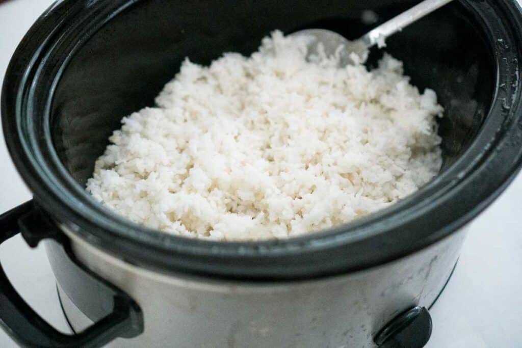 slow cooker with white rice and spoon
