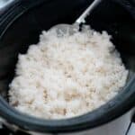 white rice in a slow cooker with large serving spoon