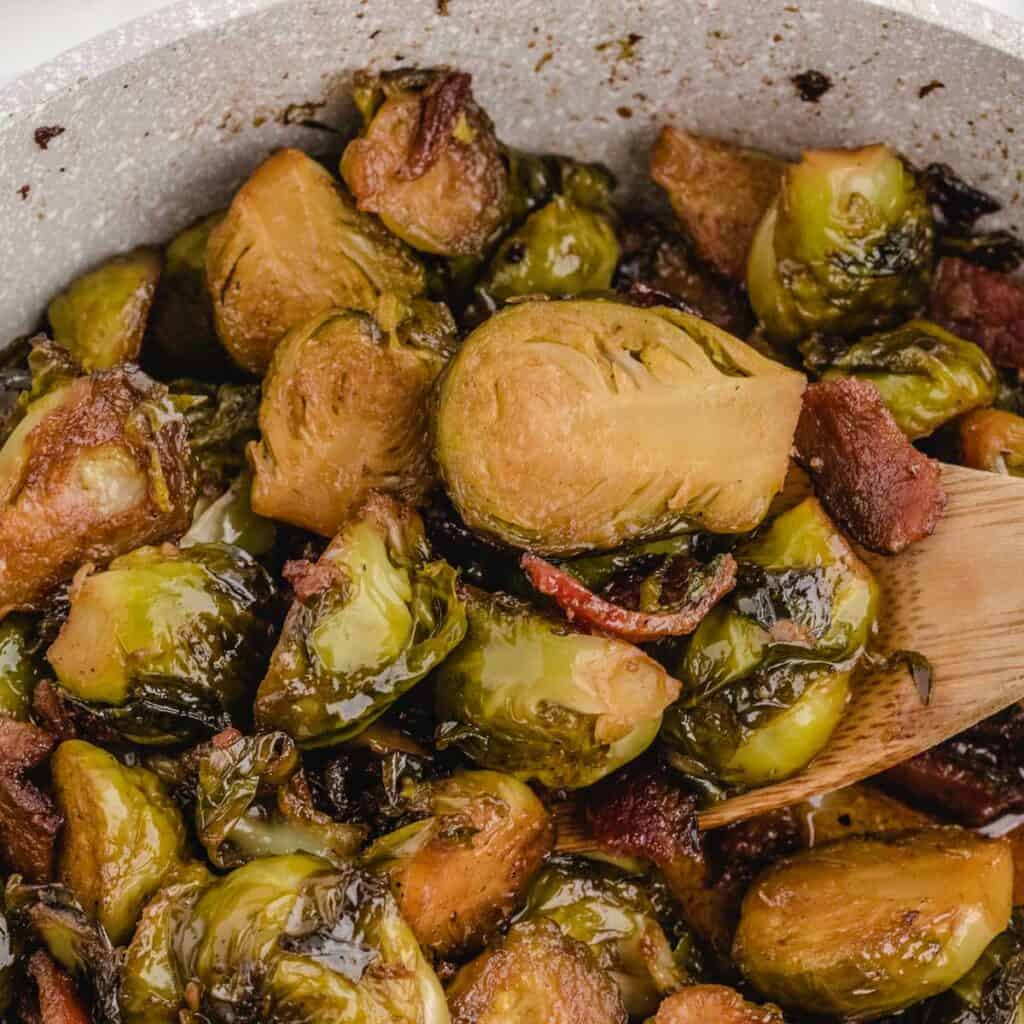 close up of brown sugar brussls sprouts and wooden spoon
