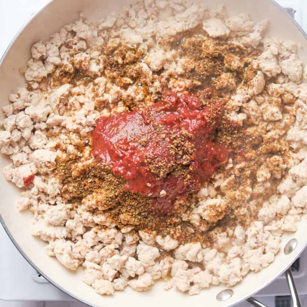 ground turkey with seasonings and tomato paste in skillet