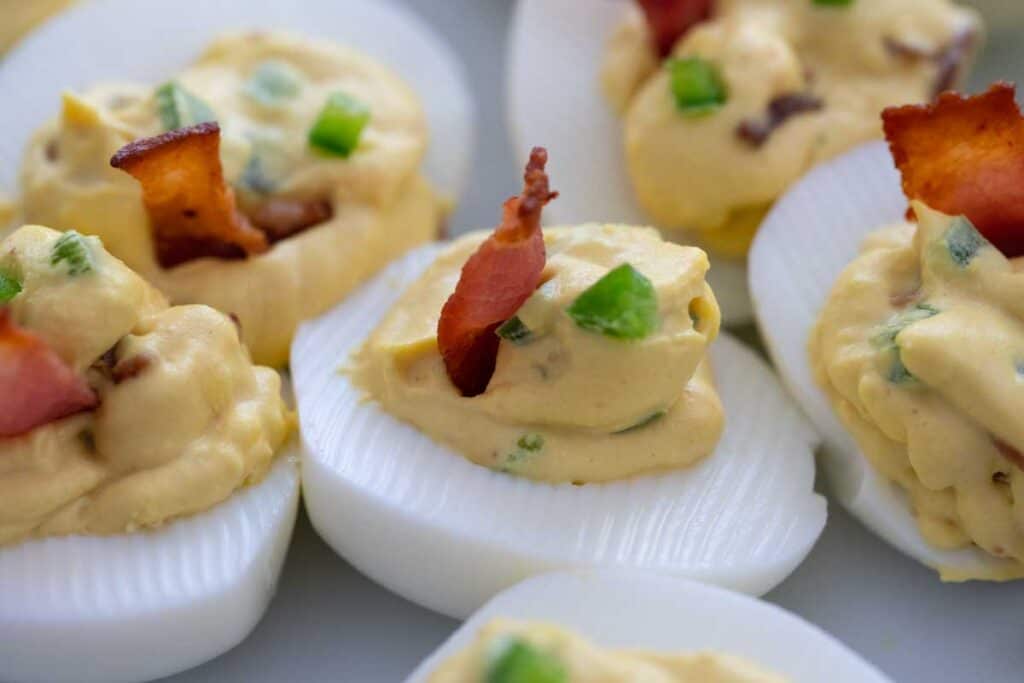 bacon jalapeno deviled eggs on white plate
