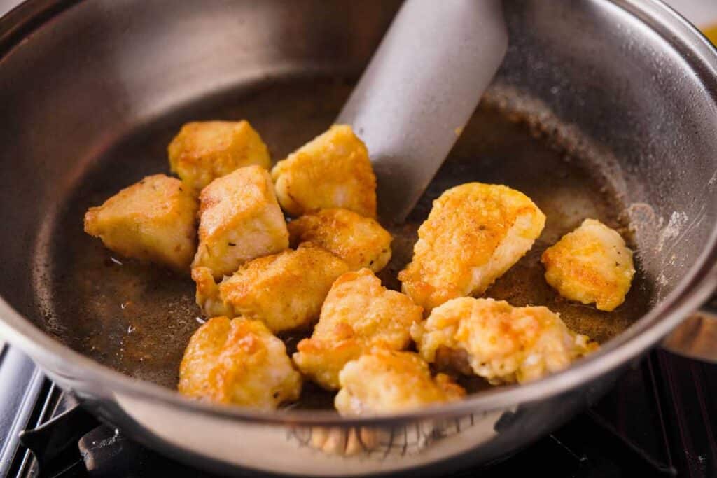 sautéing chicken pieces in pan