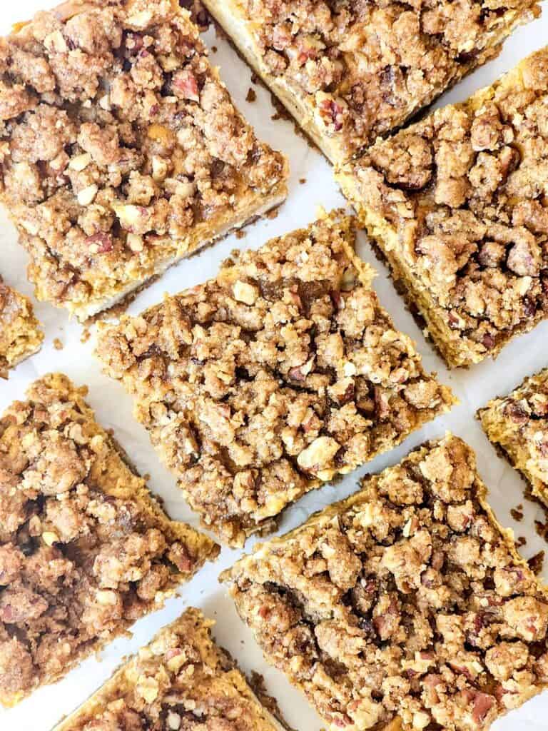 pumpkin cheesecake bar squares on parchment paper