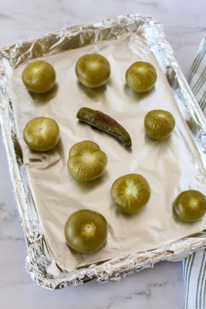 tomatillos and pepper after roasting on foil lined baking sheet