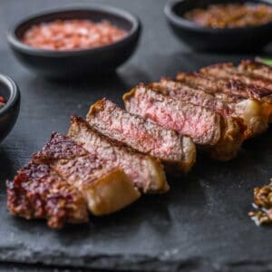 sliced tri tip steak on slate cutting board