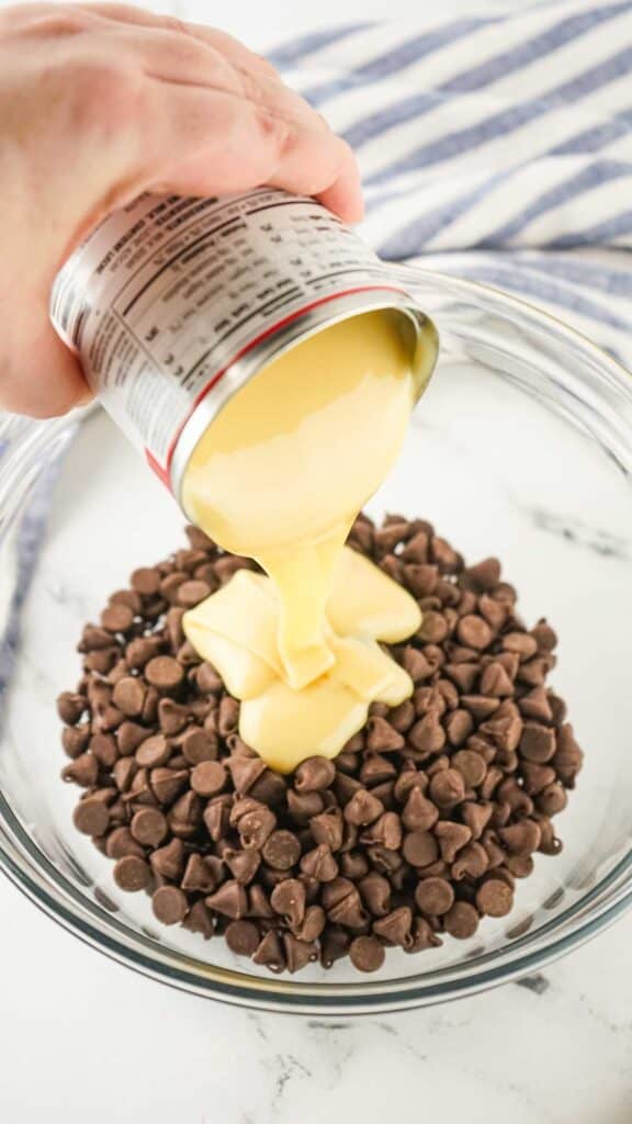 pouring condensed milk over chocolate chips