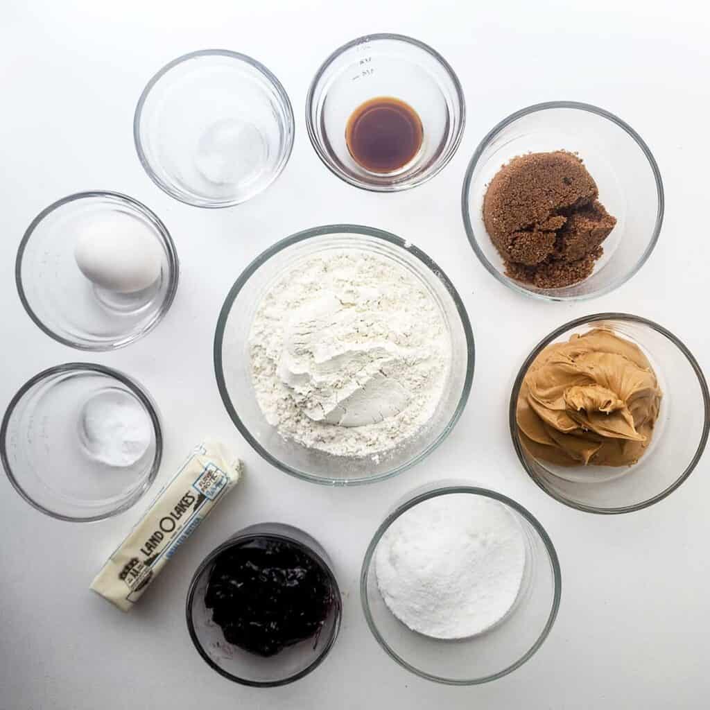 peanut butter and jelly cookie ingredients in glass bowls