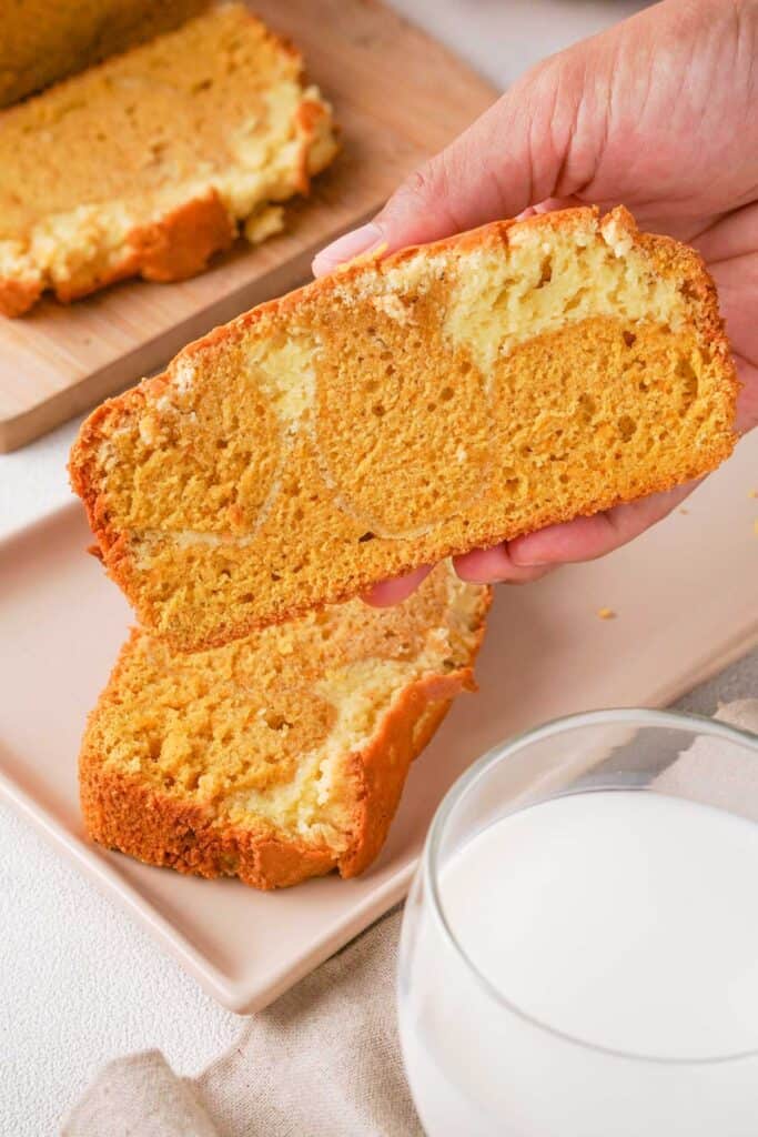hand holding slice of cream cheese swirled pumpkin bread