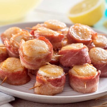 bacon wrapped scallops on white plate