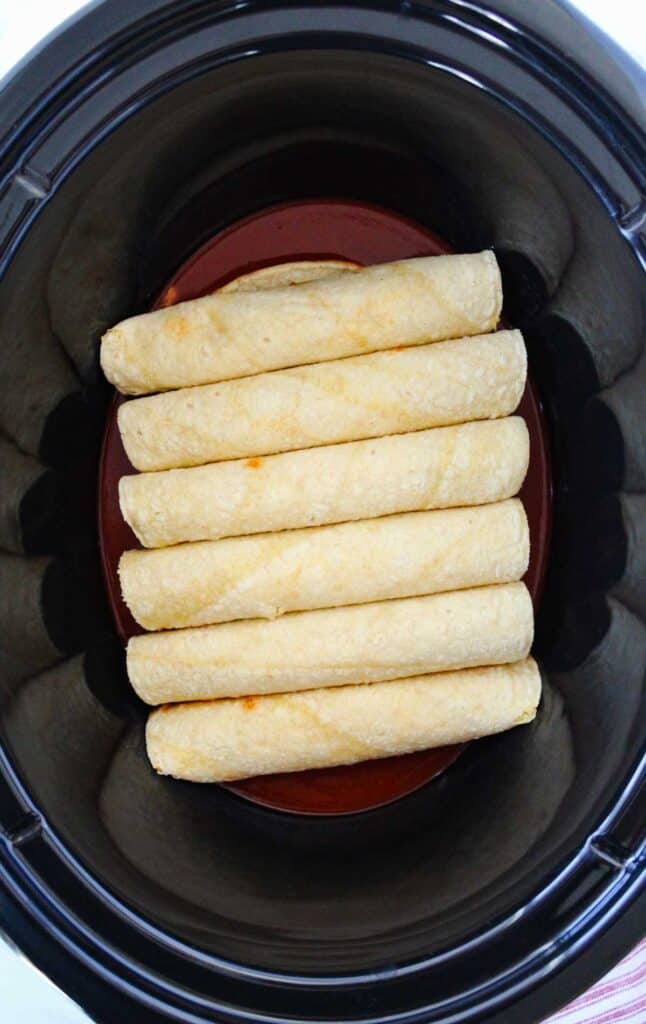 rolled tortillas in bottom of a slow cooker