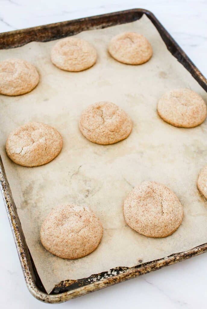 snickerdoodles on parchment paper lined baking sheet