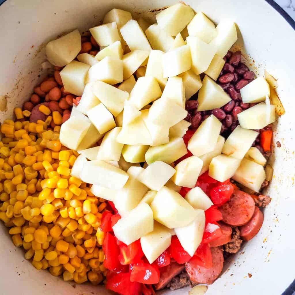 corn, potatoes, beans, and tomatoes in dutch oven