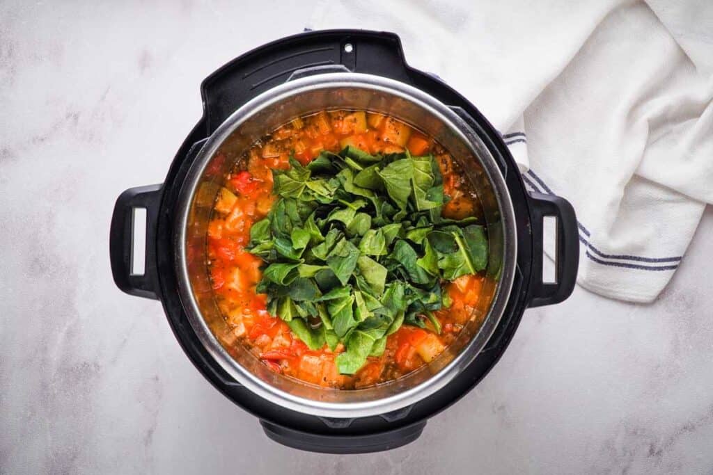 adding fresh baby spinach to minestrone soup in instant pot