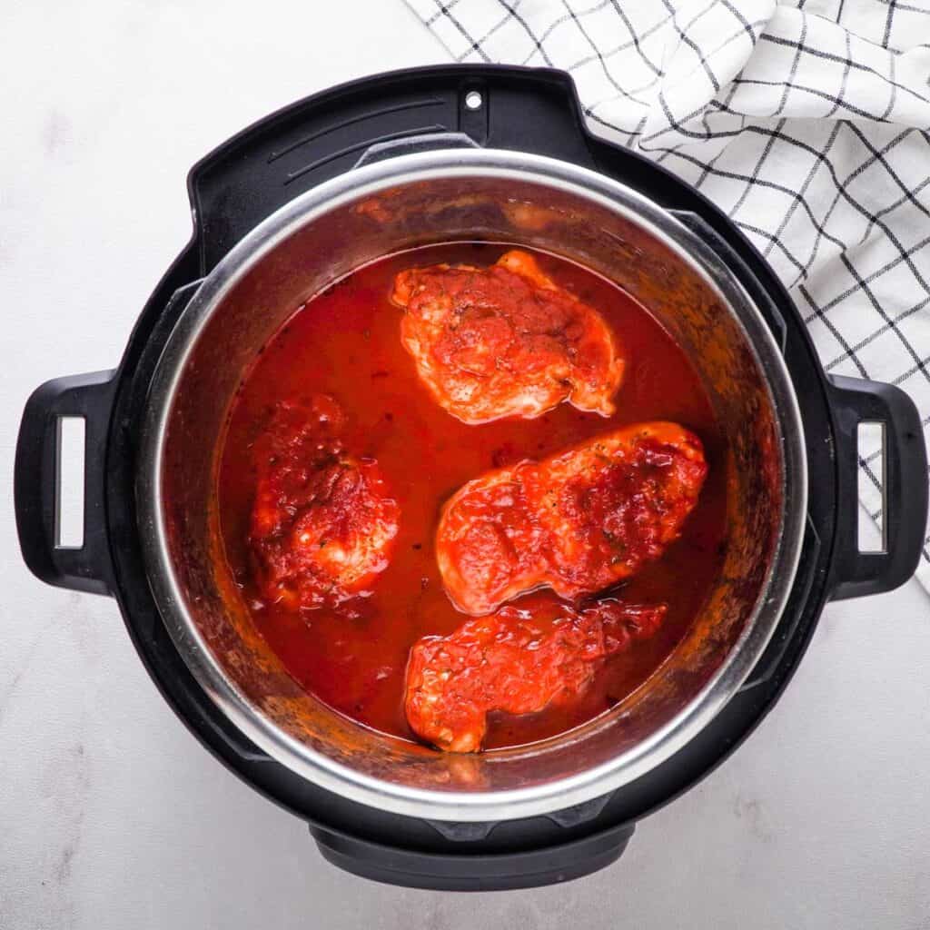 chicken covered in marinara sauce in Instant Pot