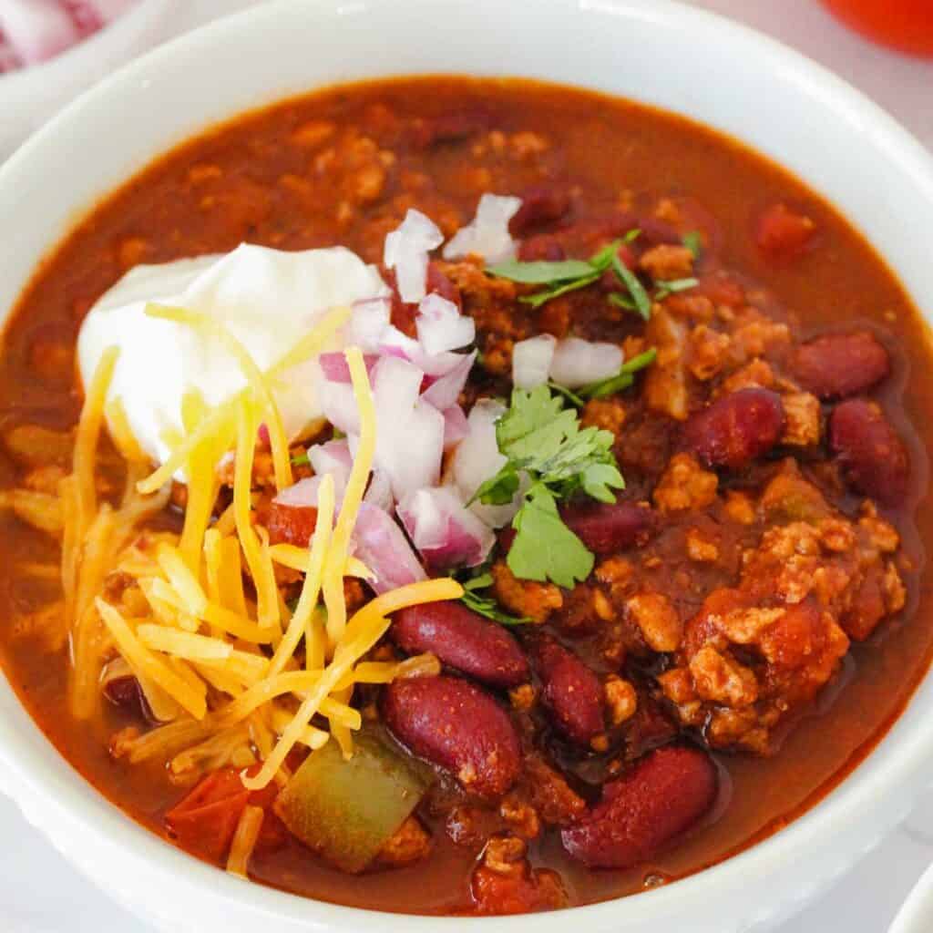 close up of white bowl with slow cooker turkey chili