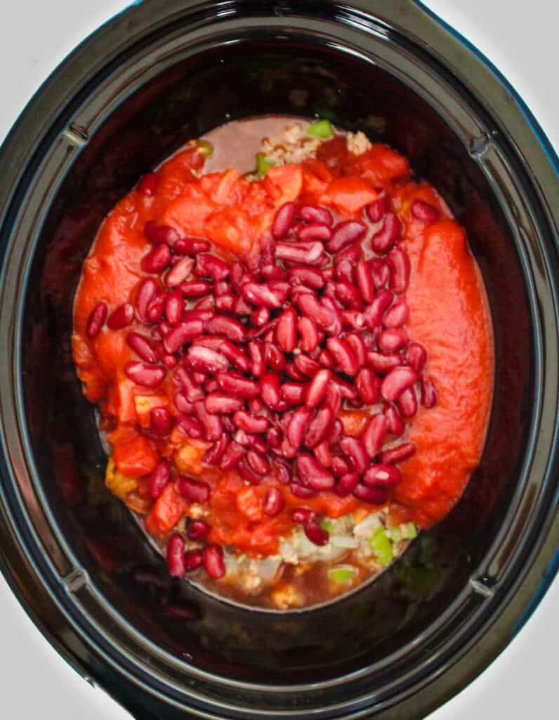 chili ingredients in a slow cooker before mixing