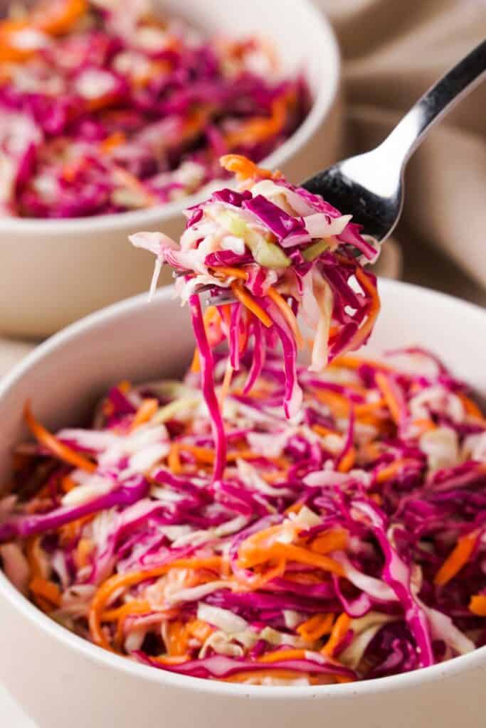 fork with coleslaw over bowl of coleslaw