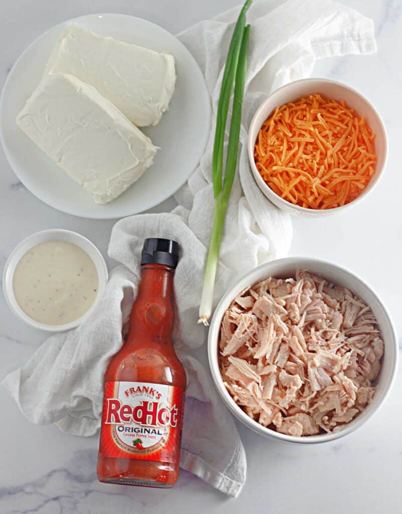 buffalo chicken dip ingredients on marble countertop