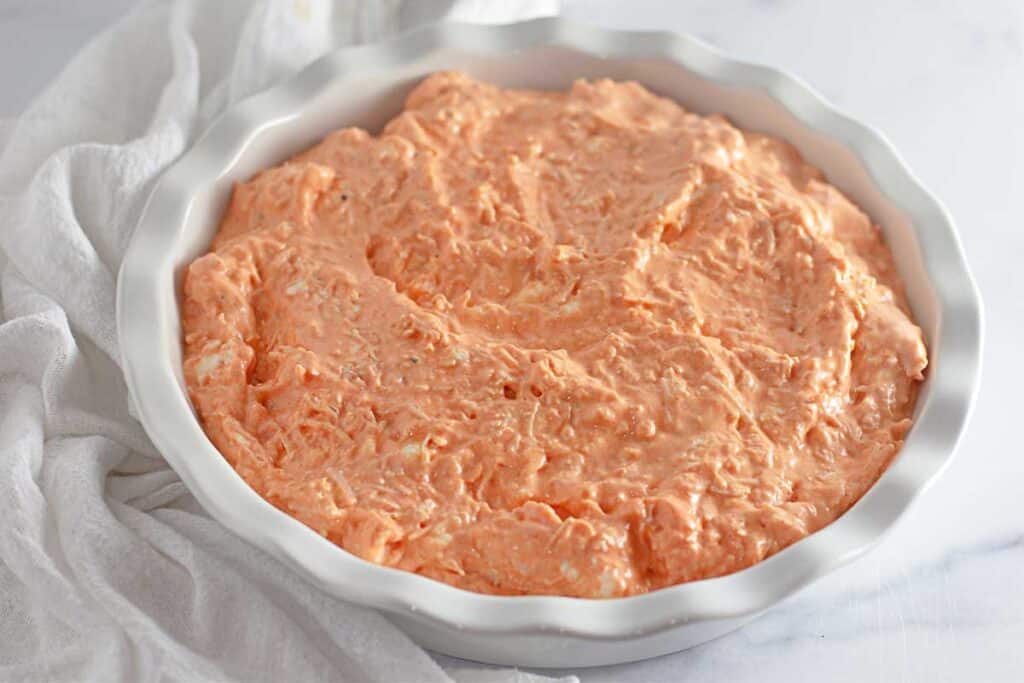 unbaked buffalo chicken dip in white dish