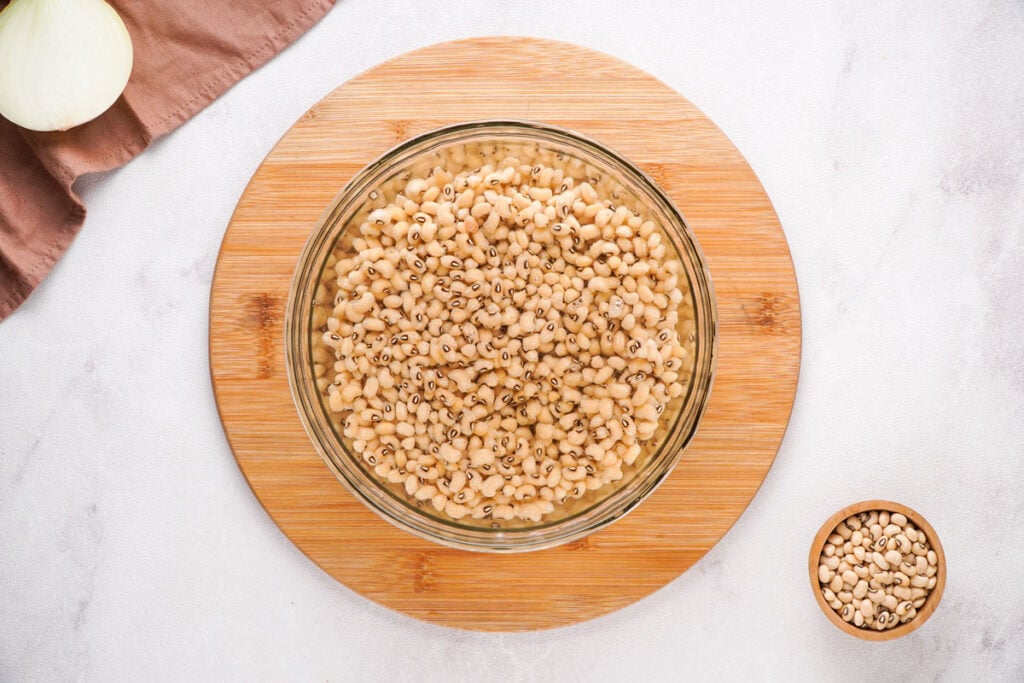 black eyed peas soaking in water in a glass bowl