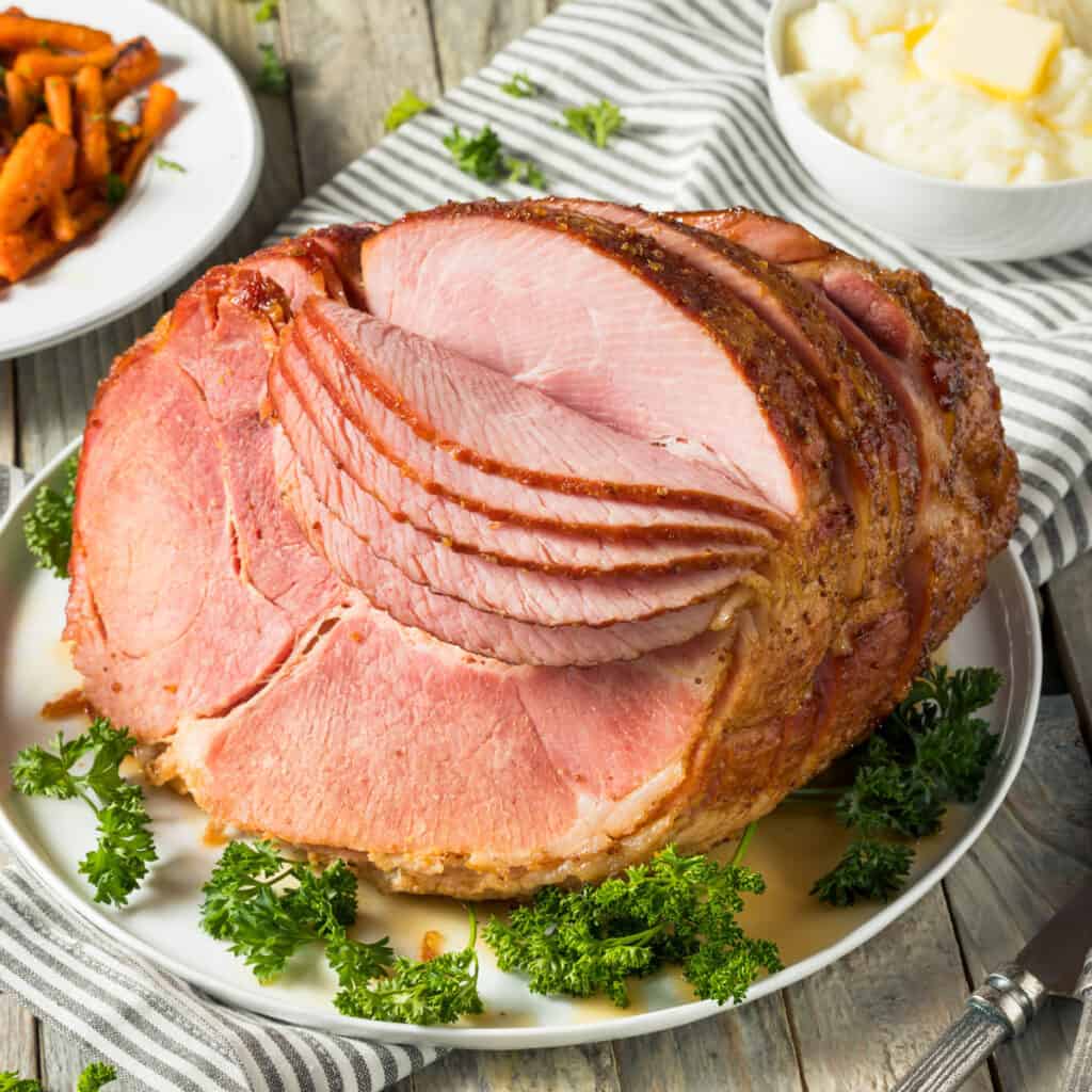 sliced ham on tale with sides