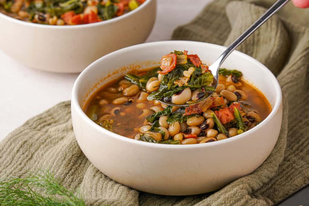 black-eyed peas and greens in bowl with spoonful held over top