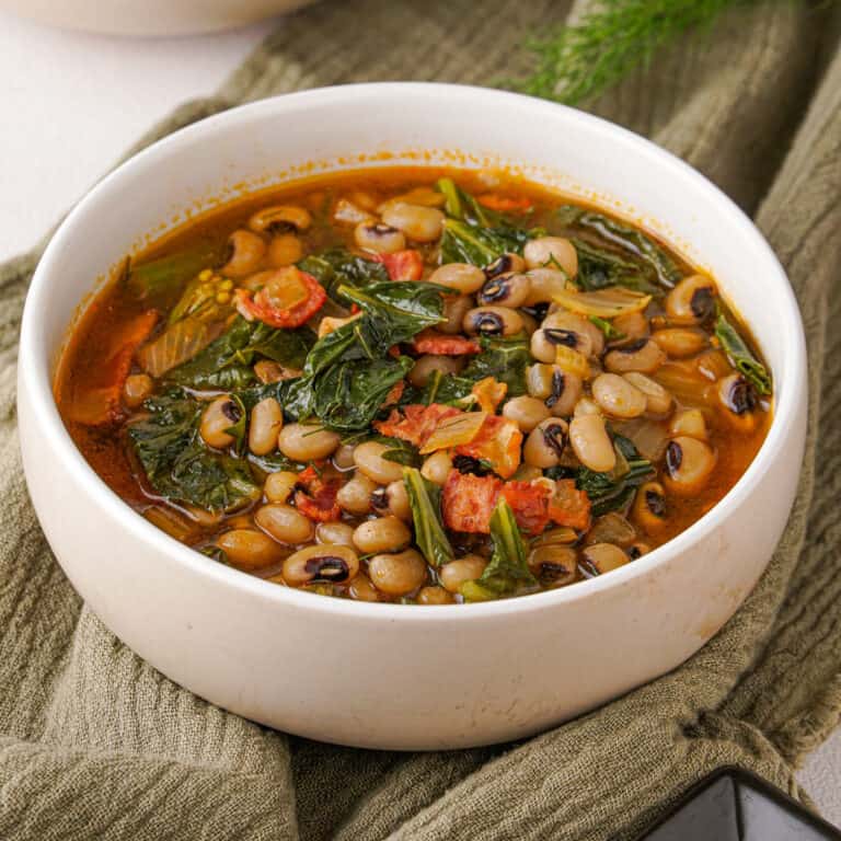 black eyed peas and greens in white bowl