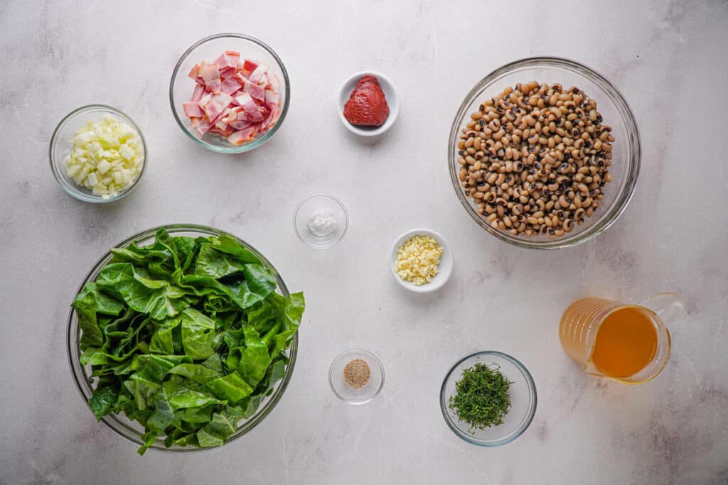 black-eyed peas and greens ingredients in glass bowls on counter