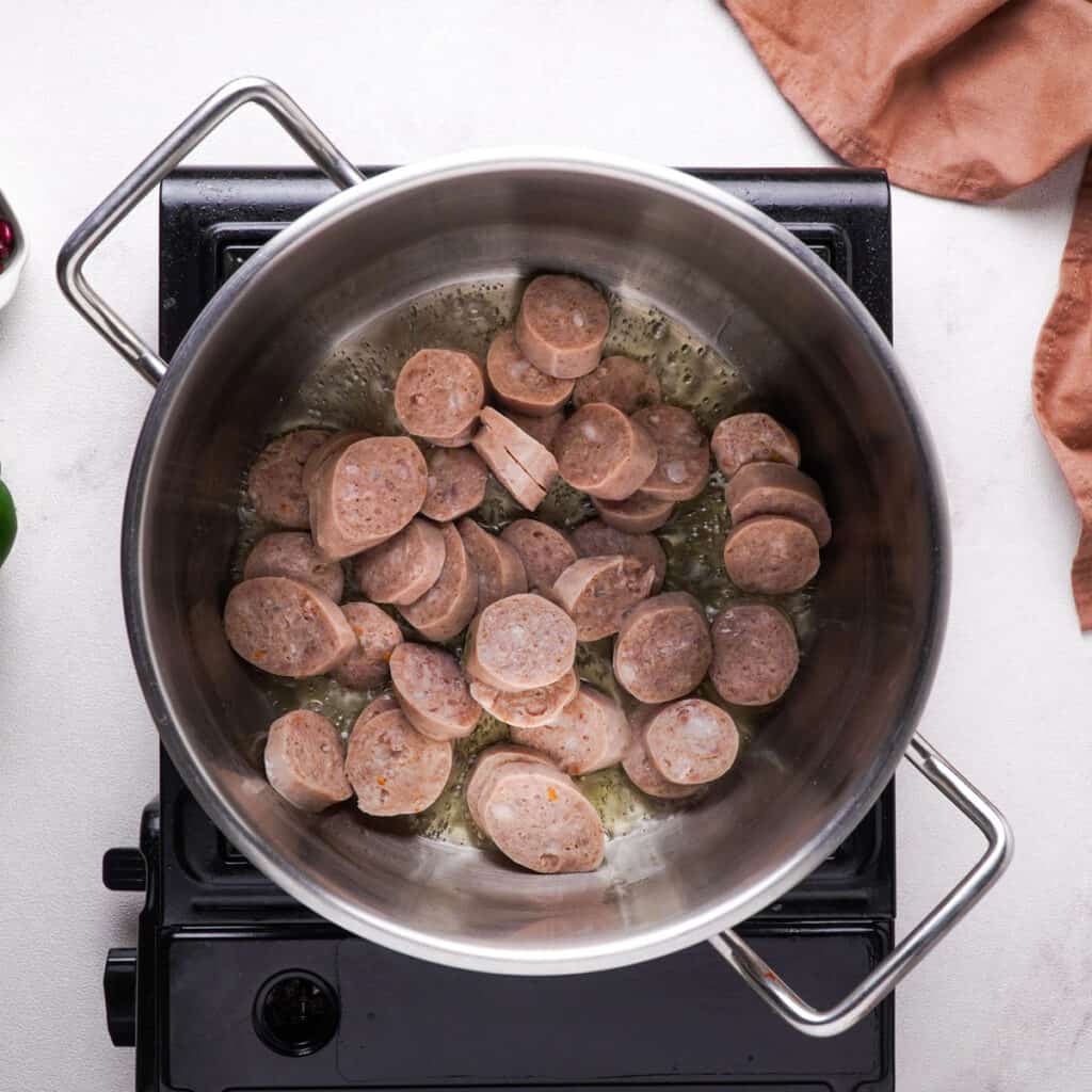 sliced andouille sausage in pot